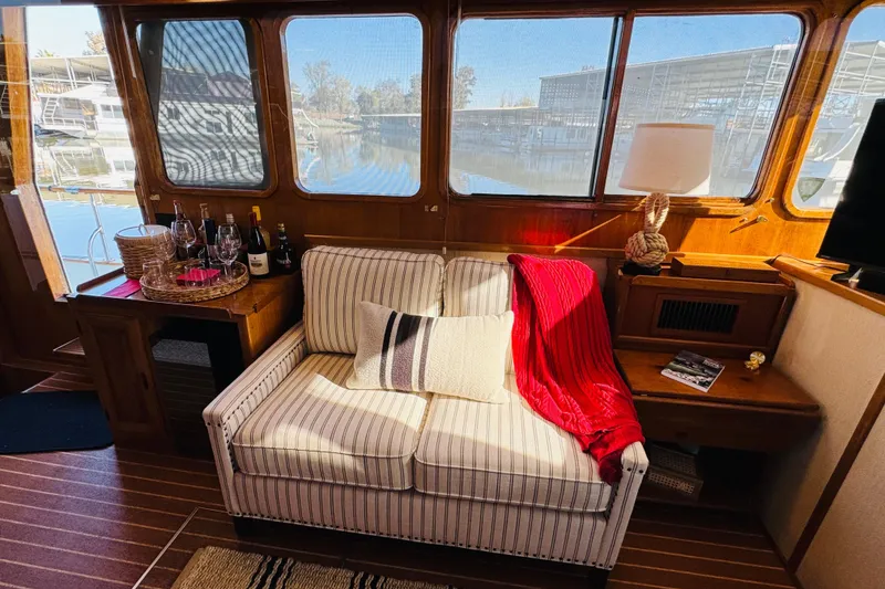 Slide: The Image of Interior of 1978 Californian 42 LRC yacht with cozy seating and scenic marina view. - 28