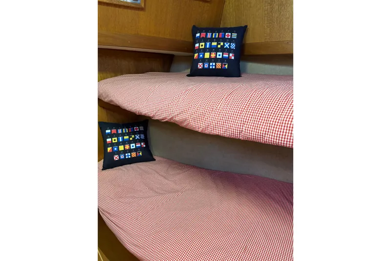 Slide: The Image of Bunk beds with checkered bedding and nautical pillows on a 1978 Californian 42 LRC boat. - 44