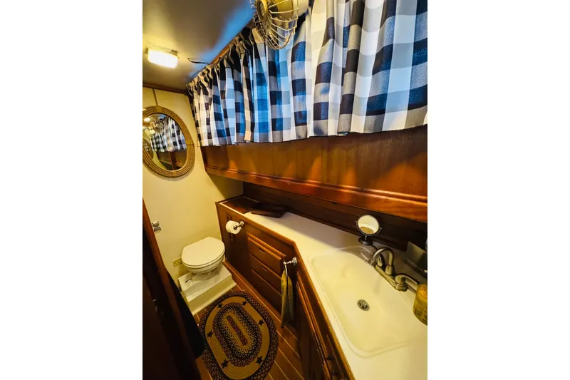 Slide: The Image of 1978 Californian 42 LRC yacht bathroom with checkered curtains and wooden cabinetry. - 46