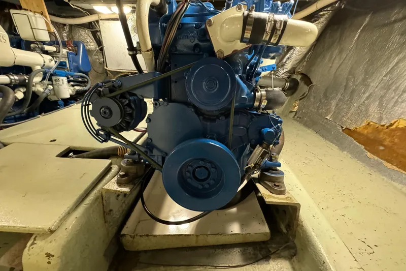 Slide: The Image of Engine room of a 1978 Californian 42 LRC boat, featuring a blue marine engine. - 58