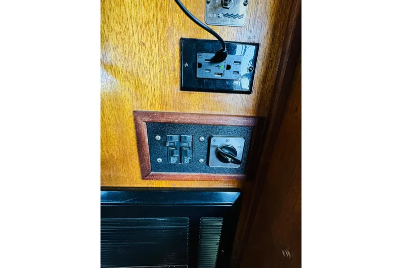 Slide: The Image of Electrical panel on a 1978 Californian 42 LRC boat, featuring switches and outlets. - 64