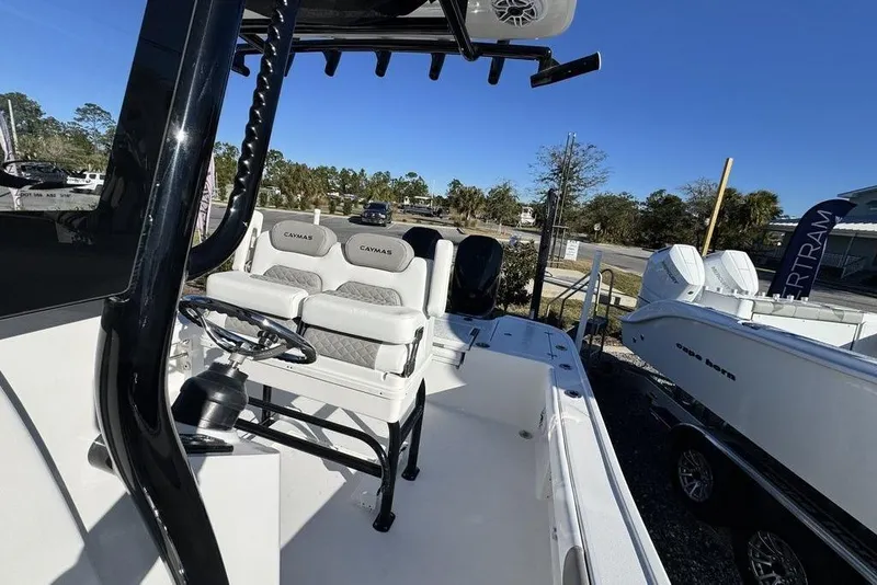 Slide: The Image of 2026 Caymas 281 HB boat interior with steering wheel and seating, displayed outdoors. - 18