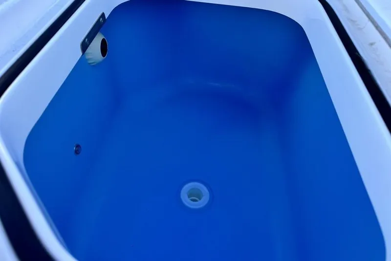 Slide: The Image of Livewell compartment in 2026 Caymas 281 HB boat, featuring a blue interior. - 27