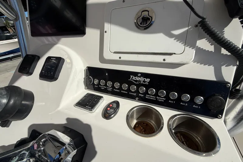 Slide: The Image of Control panel of a 2020 Tideline 235 Hybrid boat with various switches and controls. - 17