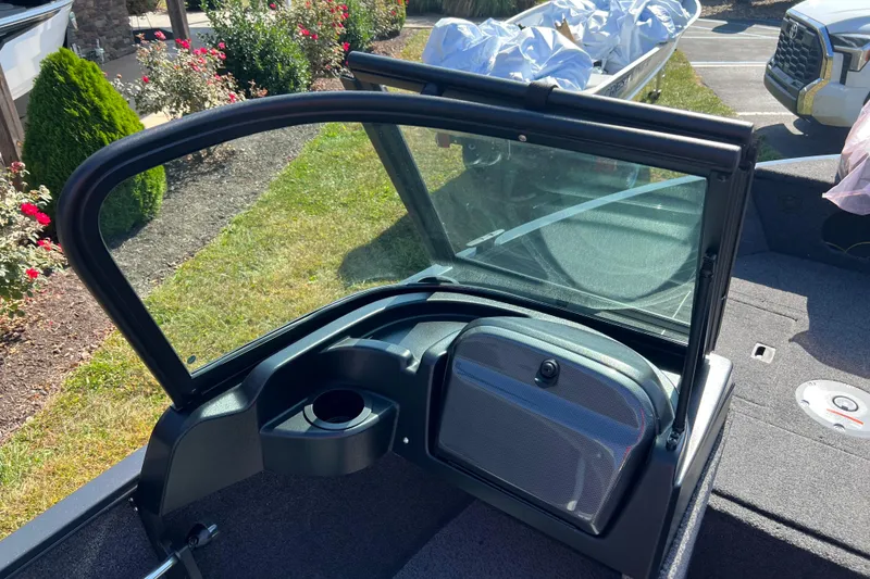 Slide: The Image of 2026 Crestliner 1650 Hawk boat interior with windshield and console, parked outdoors. - 12