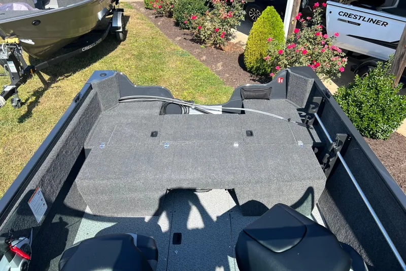 Slide: The Image of 2026 Crestliner 1650 Hawk boat interior with seating and storage, displayed outdoors. - 14