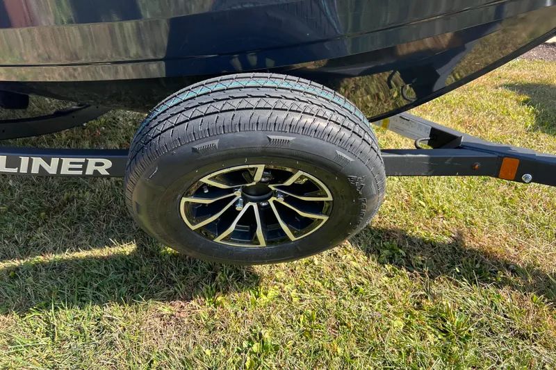 Slide: The Image of Trailer wheel of 2026 Crestliner 1650 Hawk boat on grass. - 2