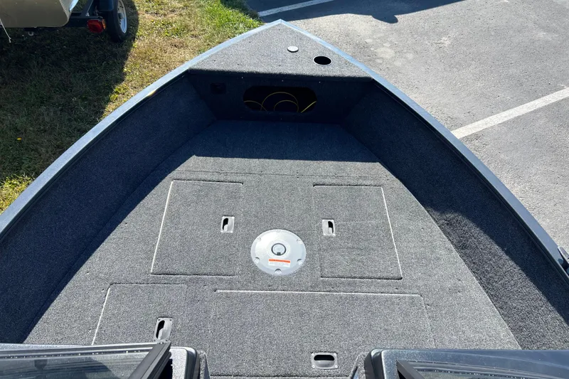 Slide: The Image of 2026 Crestliner 1650 Hawk boat interior with carpeted deck and storage compartments. - 5