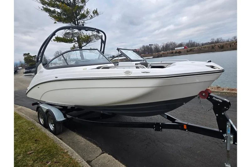 Slide: The Image of 2017 Yamaha Boats 212 Limited S on trailer by a lakeside road. - 8