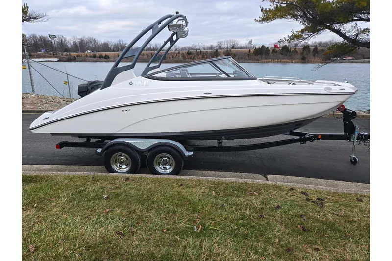 Slide: The Image of 2017 Yamaha Boats 212 Limited S on trailer by a lakeside road. - 9