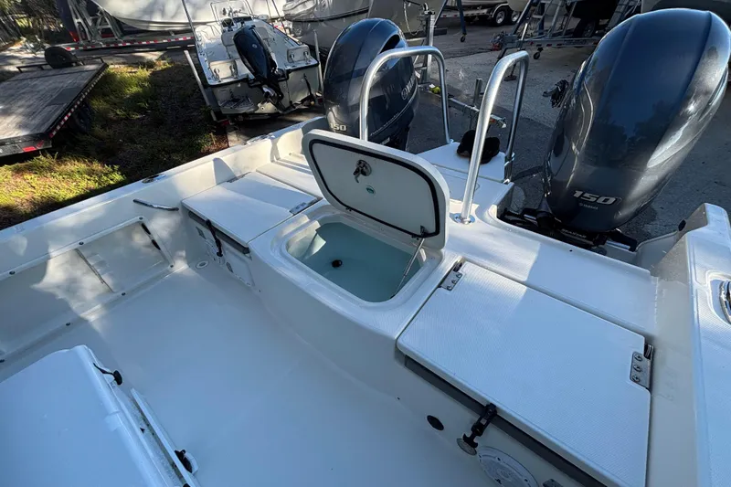 Slide: The Image of 2022 World Cat 235 CC boat interior with open storage and dual engines. - 13