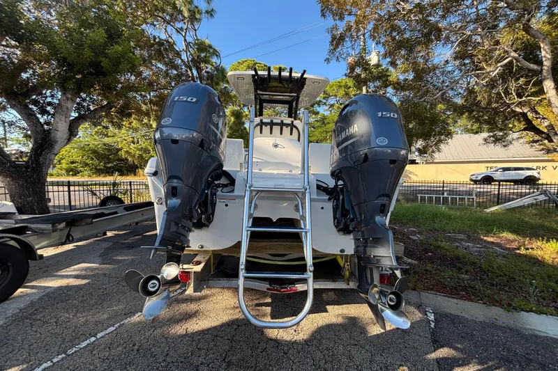 Slide: The Image of 2022 World Cat 235 CC boat with dual Yamaha 150 engines, parked outdoors. - 4