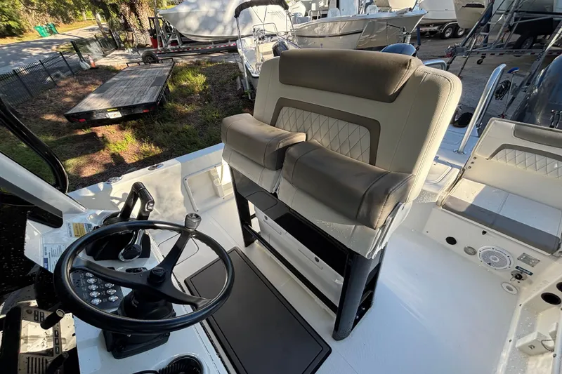 Slide: The Image of 2022 World Cat 235 CC boat interior with steering wheel and cushioned seating. - 7