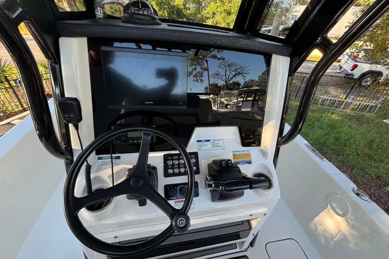 Slide: The Image of 2022 World Cat 235 CC boat dashboard with steering wheel and Garmin display. - 8