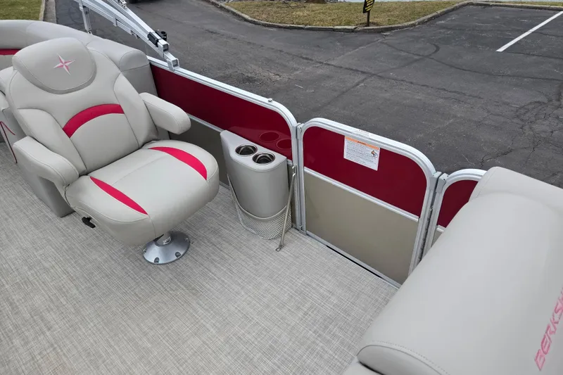Slide: The Image of 2008 Berkshire CPT 24 RFX boat interior with beige and red seating, cup holders, and carpeted floor. - 12