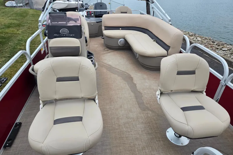 Slide: The Image of 2020 Sun Tracker Bass Buggy 18 DLX pontoon boat interior with beige seating and lake view. - 11