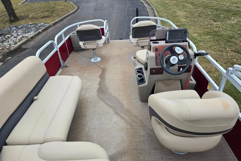 Slide: The Image of 2020 Sun Tracker Bass Buggy 18 DLX pontoon boat interior with beige seating and steering console. - 21
