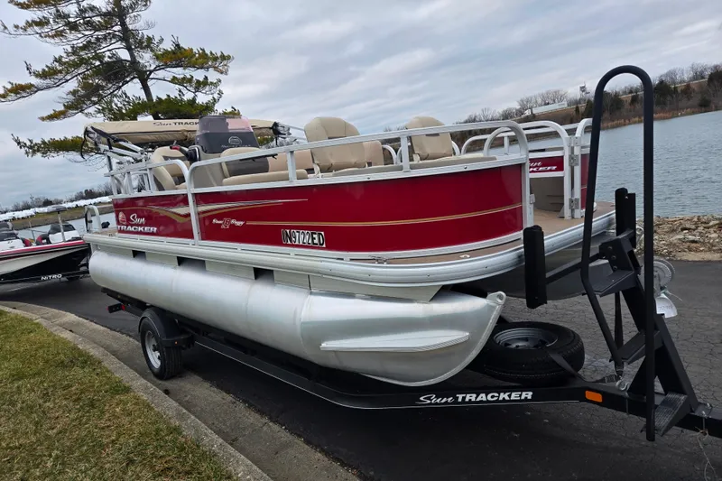 Slide: The Image of 2020 Sun Tracker Bass Buggy 18 DLX pontoon boat on trailer by a lake. - 8