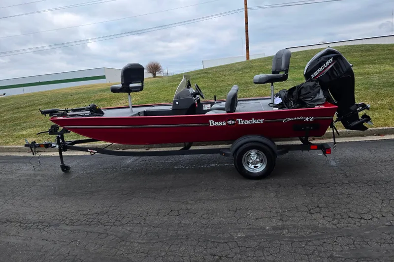 Slide: The Image of 2024 Tracker Bass Tracker Classic XL boat on trailer, red exterior, parked outdoors. - 4