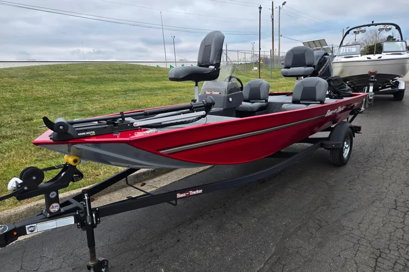 Slide: The Image of 2024 Tracker Bass Tracker Classic XL boat on trailer, red exterior, parked on pavement. - 6