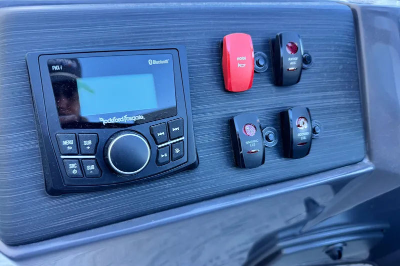 Slide: The Image of Control panel of 2026 Bennington 22 SSR with Rockford Fosgate audio system and switches. - 14