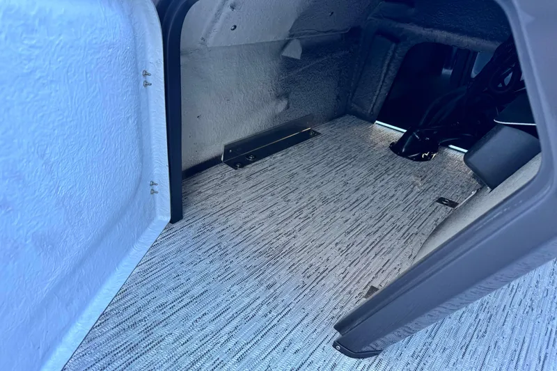 Slide: The Image of Interior storage compartment of 2026 Bennington 22 SSR boat, featuring textured flooring. - 16