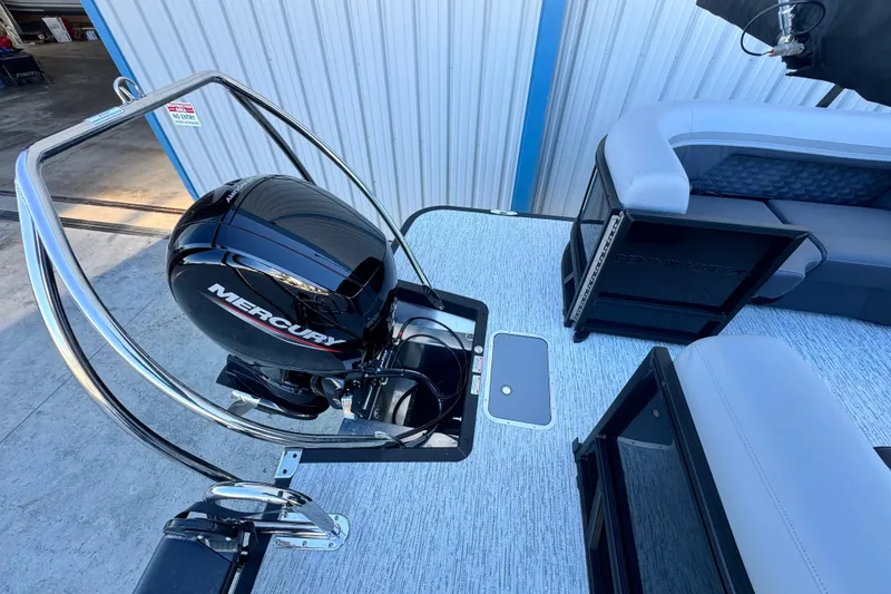 Slide: The Image of 2026 Bennington 22 SSR boat with Mercury engine, docked near a building. - 7