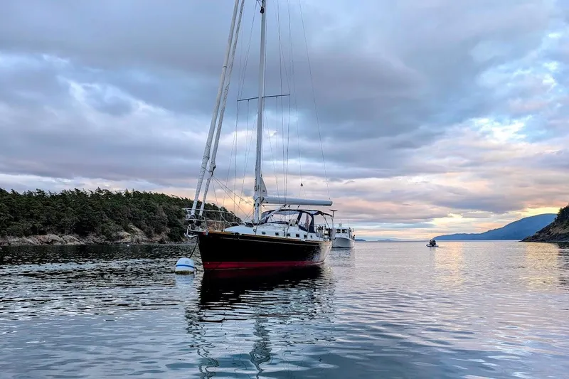 Slide: The Image of Sailboat Tartan 395 (2019) anchored in scenic coastal waters at sunset. - 3