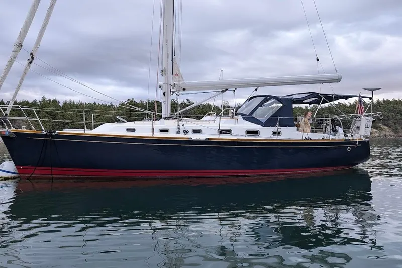 Slide: The Image of Sailboat Tartan 395, 2019 model, anchored on calm water with forested background. - 6