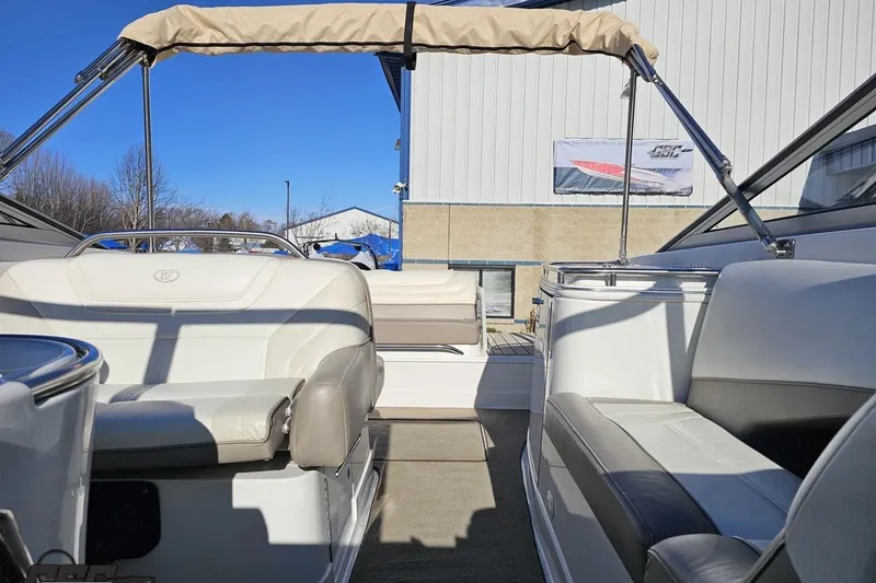Slide: The Image of 2000 Cobalt 293 boat interior with beige seating and canopy under clear blue sky. - 105