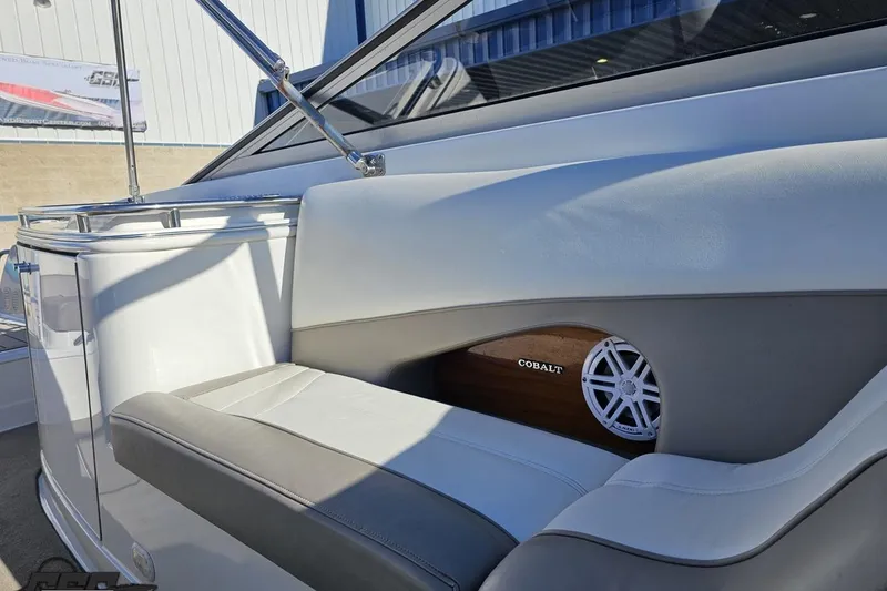 Slide: The Image of Interior of a 2000 Cobalt 293 boat, featuring white and gray seating with a speaker. - 106