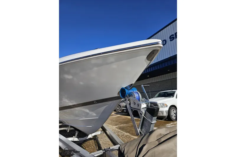 Slide: The Image of 2000 Cobalt 293 boat on trailer, parked outside a building under clear blue sky. - 13