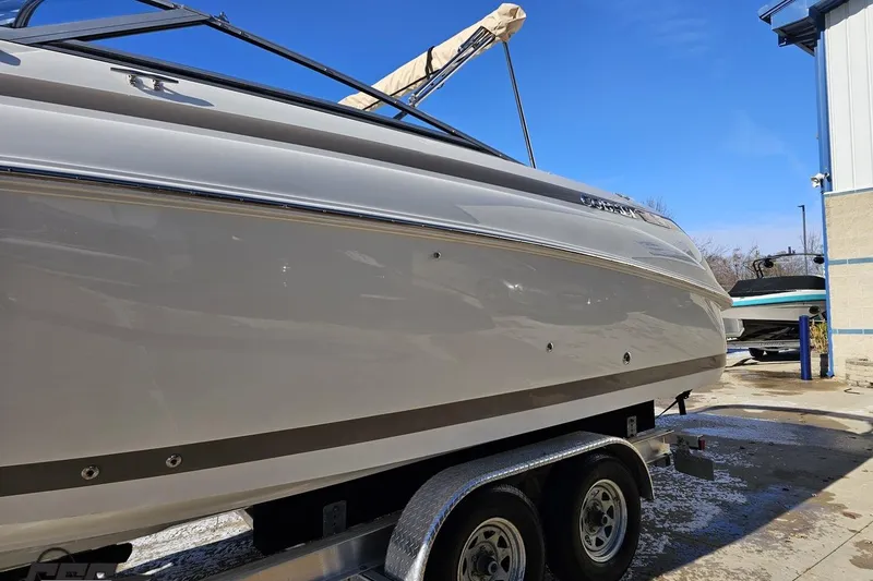 Slide: The Image of 2000 Cobalt 293 boat on trailer, side view, outdoors under clear blue sky. - 17