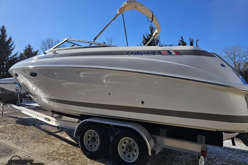 Slide: The Image of 2000 Cobalt 293 boat on trailer, parked outdoors under clear blue sky. - 21