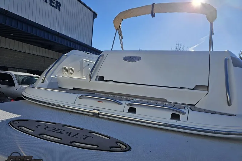 Slide: The Image of 2000 Cobalt 293 boat with sunshade, docked near a building under clear blue sky. - 27