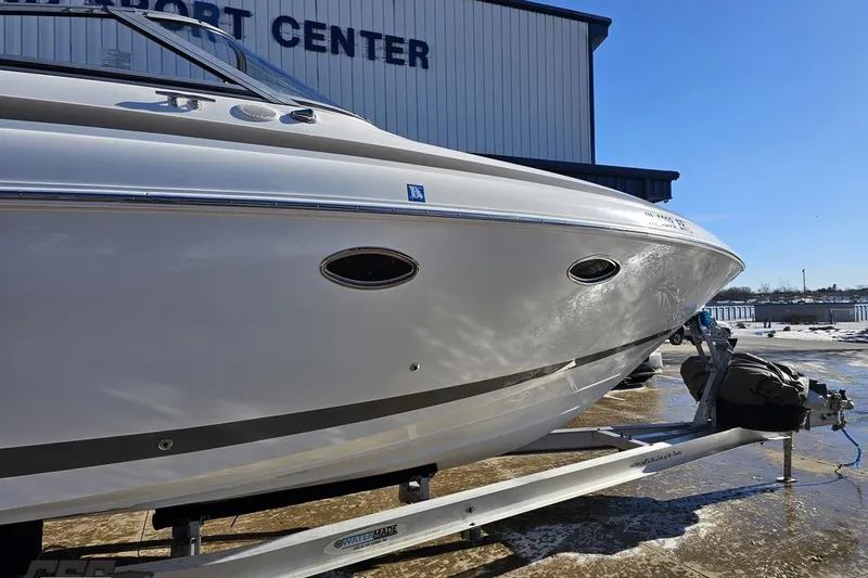 Slide: The Image of 2000 Cobalt 293 boat on trailer at a marine sport center under clear blue sky. - 4