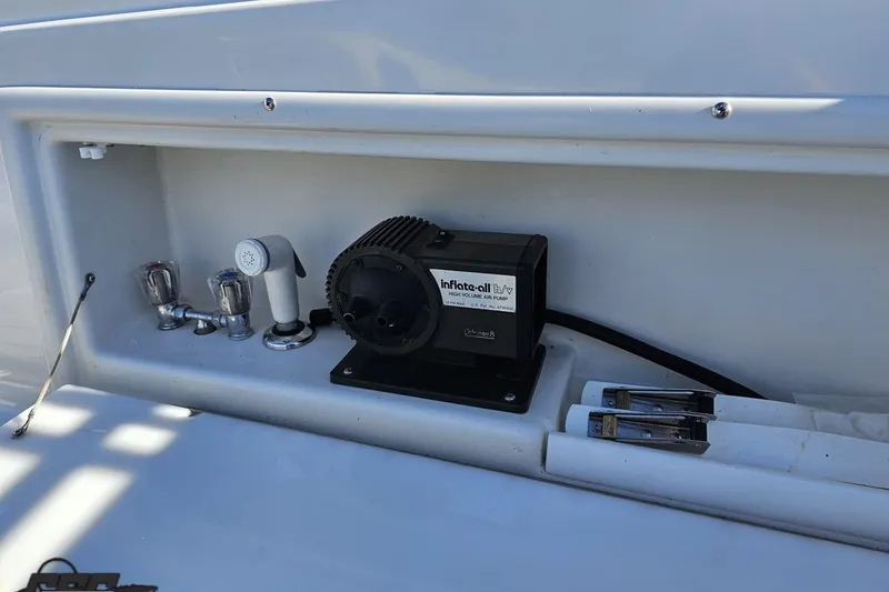 Slide: The Image of Storage compartment on a 2000 Cobalt 293 boat with air pump and faucet. - 49