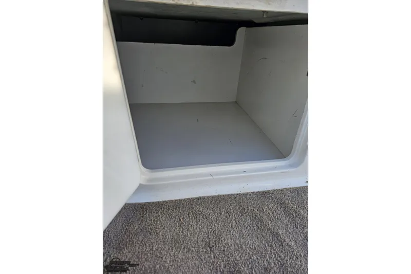 Slide: The Image of Storage compartment of a 2000 Cobalt 293 boat, featuring a clean, empty interior. - 68