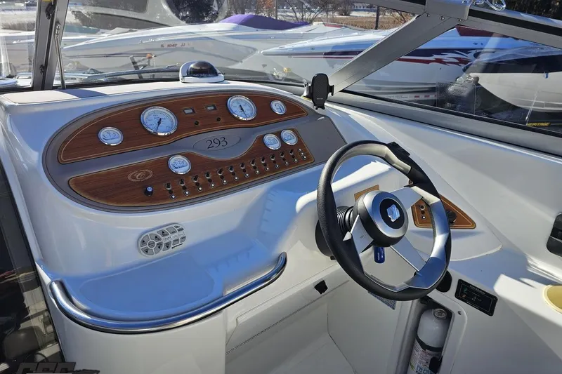 Slide: The Image of Cockpit of a 2000 Cobalt 293 boat with wood-accented dashboard and steering wheel. - 73