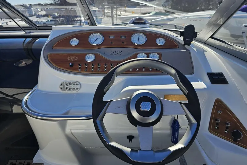 Slide: The Image of Steering wheel and dashboard of a 2000 Cobalt 293 boat, featuring wood accents and gauges. - 74