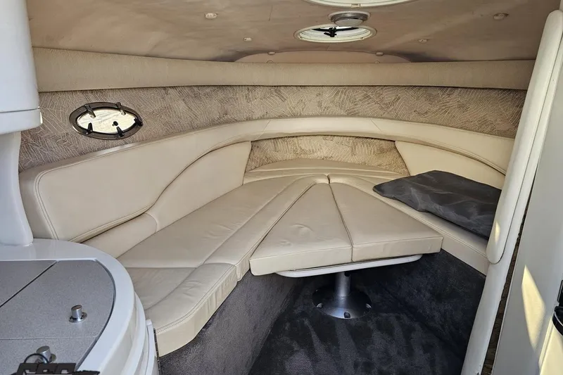 Slide: The Image of Interior of a 2000 Cobalt 293 boat with beige seating and porthole window. - 86