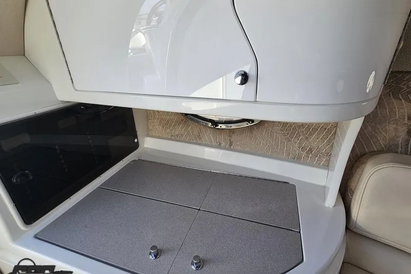 Slide: The Image of Interior of a 2000 Cobalt 293 boat featuring a sleek kitchenette area. - 90