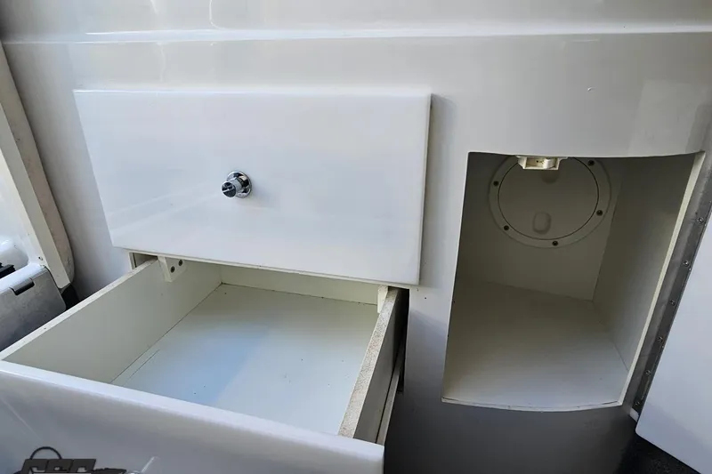 Slide: The Image of Open storage compartment and drawer in a 2000 Cobalt 293 boat interior. - 94
