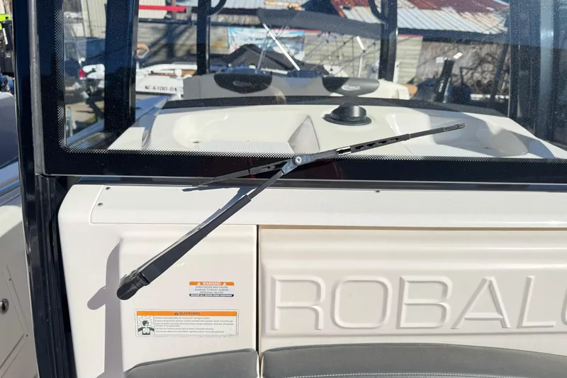 Slide: The Image of 2023 Robalo R302 Center Console windshield with wiper in a marina setting. - 13