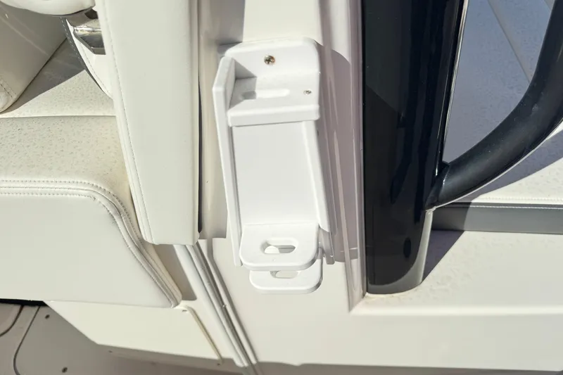 Slide: The Image of 2023 Robalo R302 Center Console boat interior detail with white upholstery and black handle. - 14