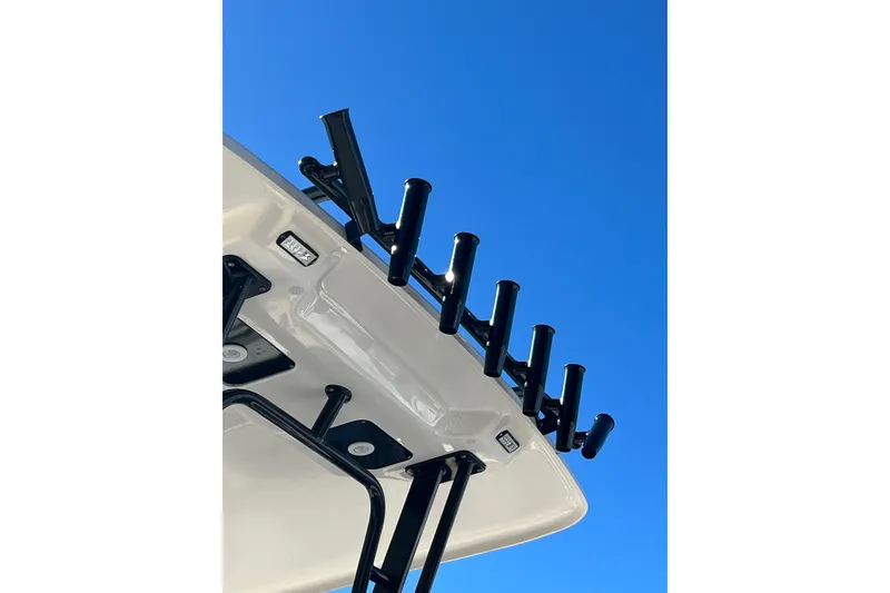Slide: The Image of 2023 Robalo R302 Center Console boat with rod holders against clear blue sky. - 17