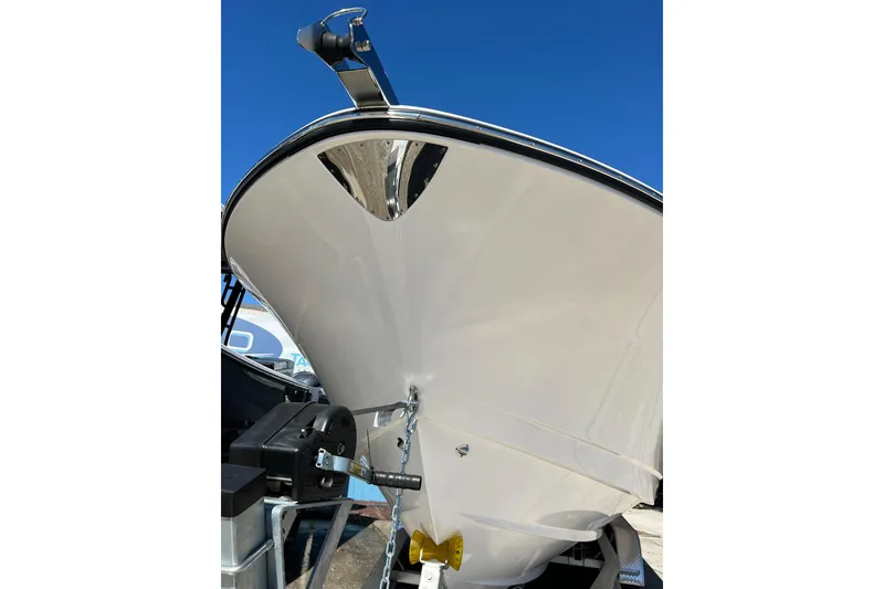 Slide: The Image of 2023 Robalo R302 Center Console boat hull, displayed on a trailer under clear blue sky. - 18