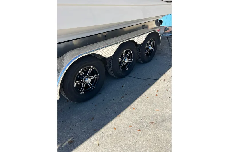 Slide: The Image of Trailer with triple axle wheels for 2023 Robalo R302 Center Console boat. - 19