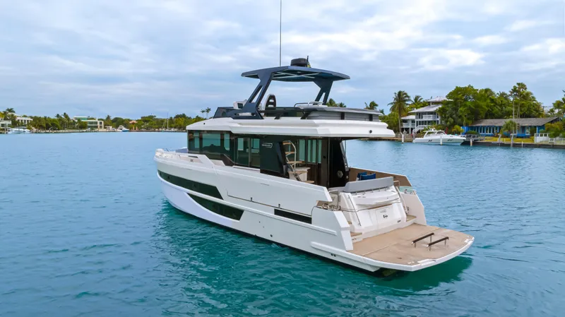 Slide: The Image of The 2026 OKEAN 52 is a sleek motor yacht on calm waters, surrounded by coastal homes. - 30