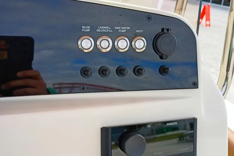 Slide: The Image of Control panel of 2026 Pioneer 202 Sportfish boat with various switches and USB port. - 12
